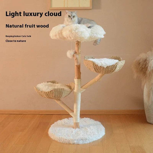 Cat tree with multiple levels and a cat on top in a room with wooden flooring and beige walls.