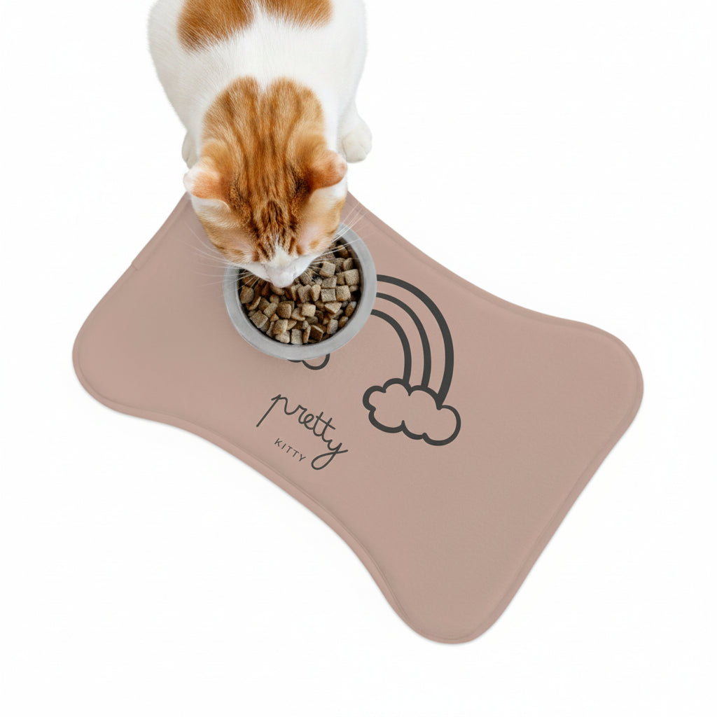 cat eating from a bowl on a 'pretty kitty' mat with a rainbow and cloud design.