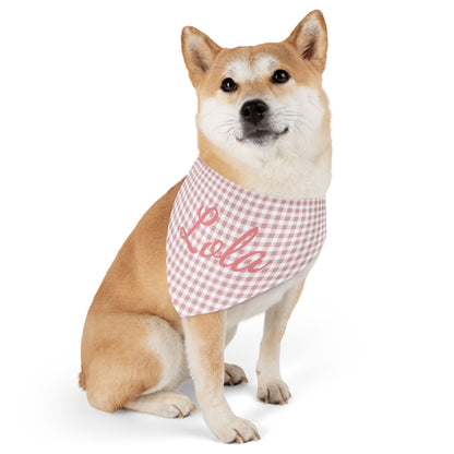 A dog wearing a personalized pink gingham pet bandana with the name 'Lola' printed on it.