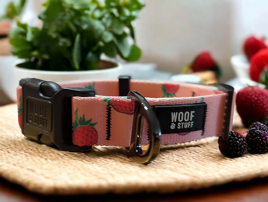 Dog collar with strawberry pattern and 'WOOF & STUFF' branding on a woven surface.