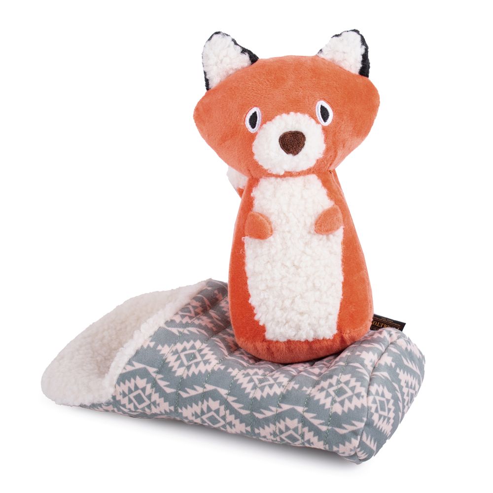 Plush fox toy on a patterned blanket with a white background