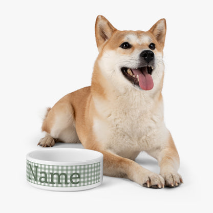 Dog sitting next to a white bowl with 'Name' text on a white background