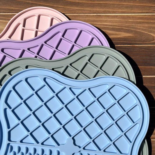Four lick mats in pink, purple, green and blue
