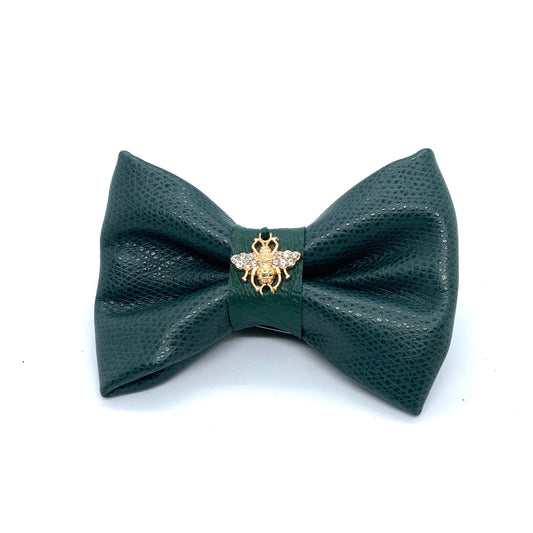 Green bow tie with a bee pin on a white background