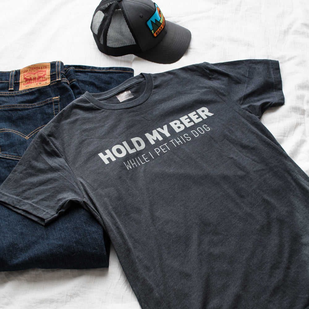 Gray t-shirt with humorous text, jeans, and cap on a white background