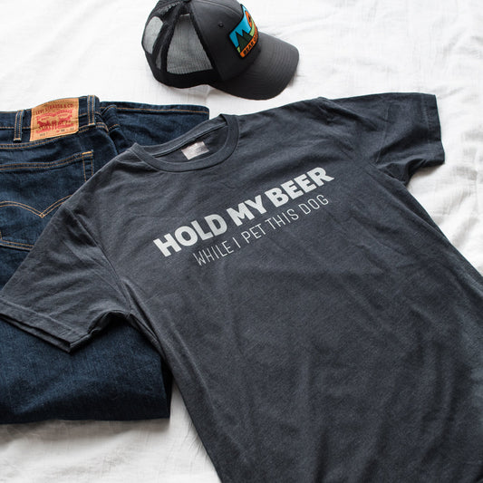 Gray t-shirt with humorous text, jeans, and cap on a white background