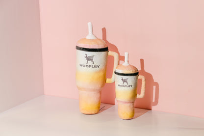 Two gradient tumbler mugs with 'Woofley' branding on a pink background