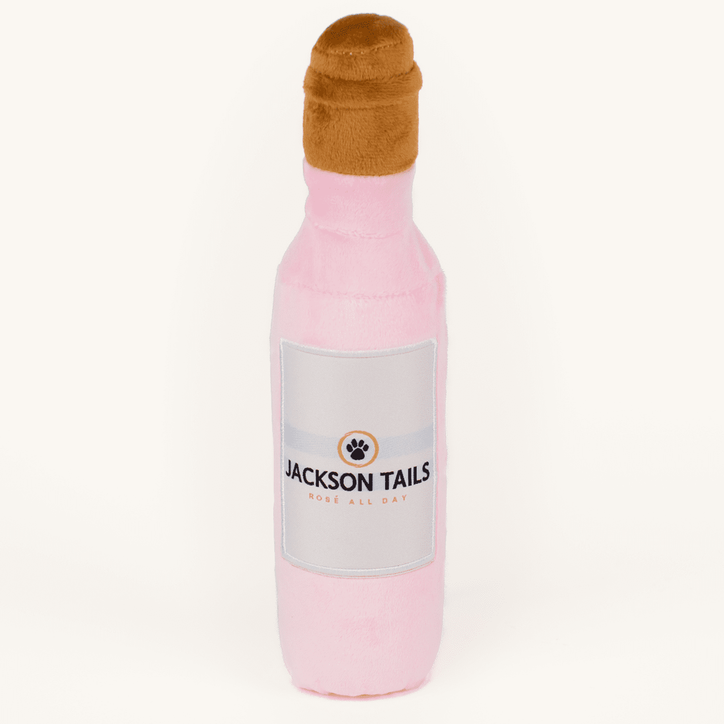 Pink bottle-shaped dog toy with a brown cap on a white background, branded 'Jackson Tails'.